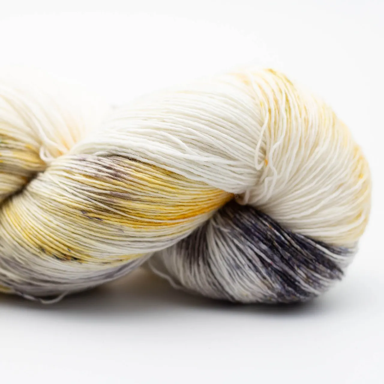 Marina 9001 Oro Viejo (Gelb. Weiß. Schwarz) von Manos del Uruguay. Ein luxuriöses handgefärbtes Lace-Garn das durch seine besondere Feinheit und Weichheit besticht mit intensiven Farben und leichtem Glanz. Ideal für filigrane und leichte Projekte wie Tücher Schals und Stolen.